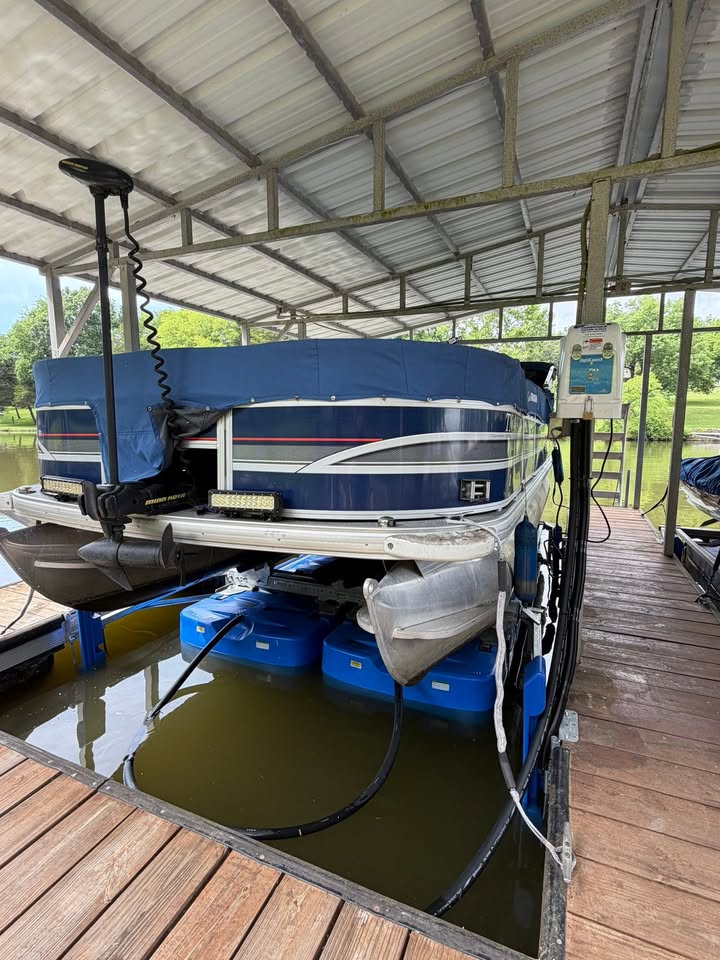 Pontoon boat on a HydroHoist boat lift inside a covered dock in Middle Tennessee